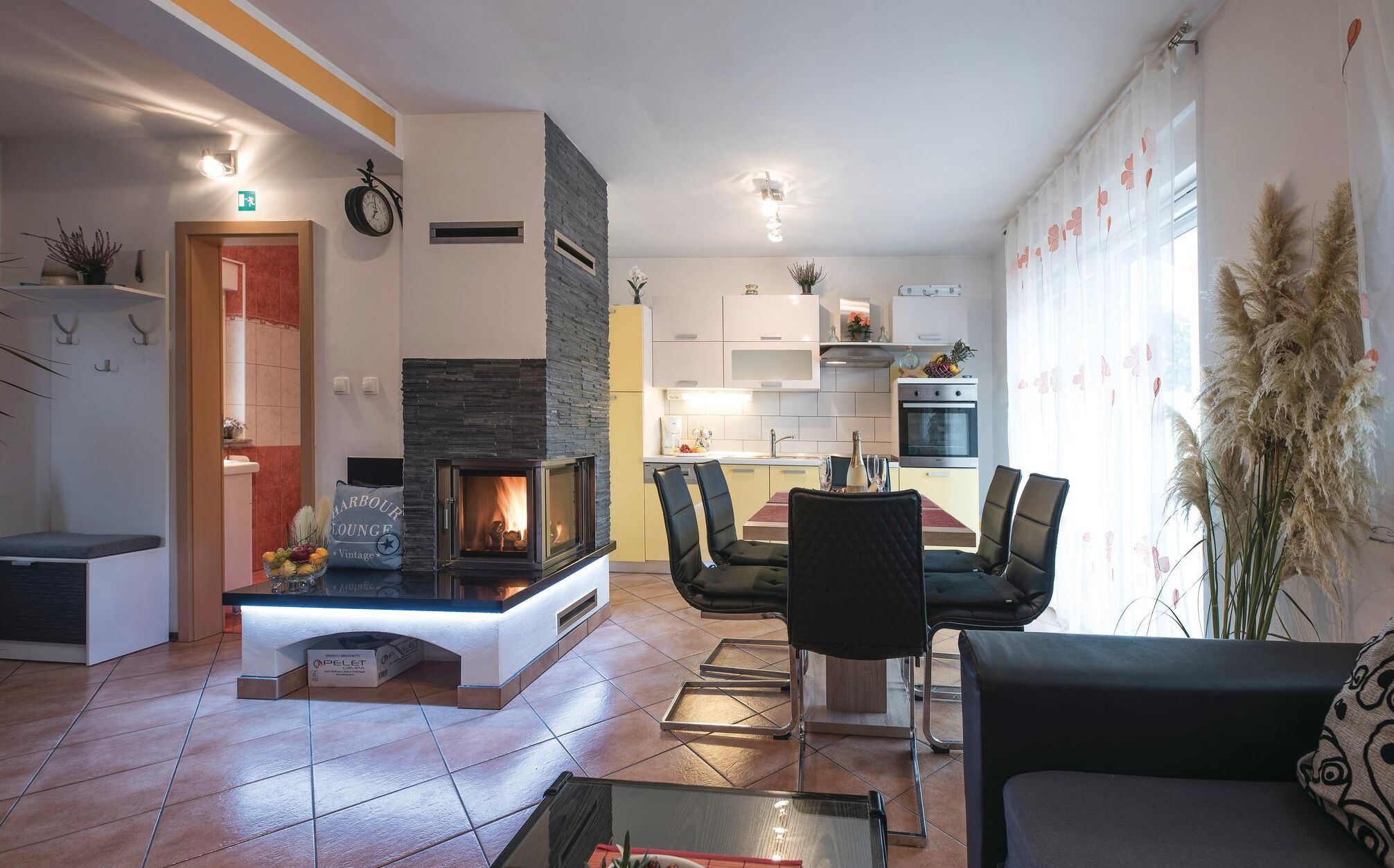 Ein modernes Wohnzimmer mit Kamin, Essbereich und Küche.