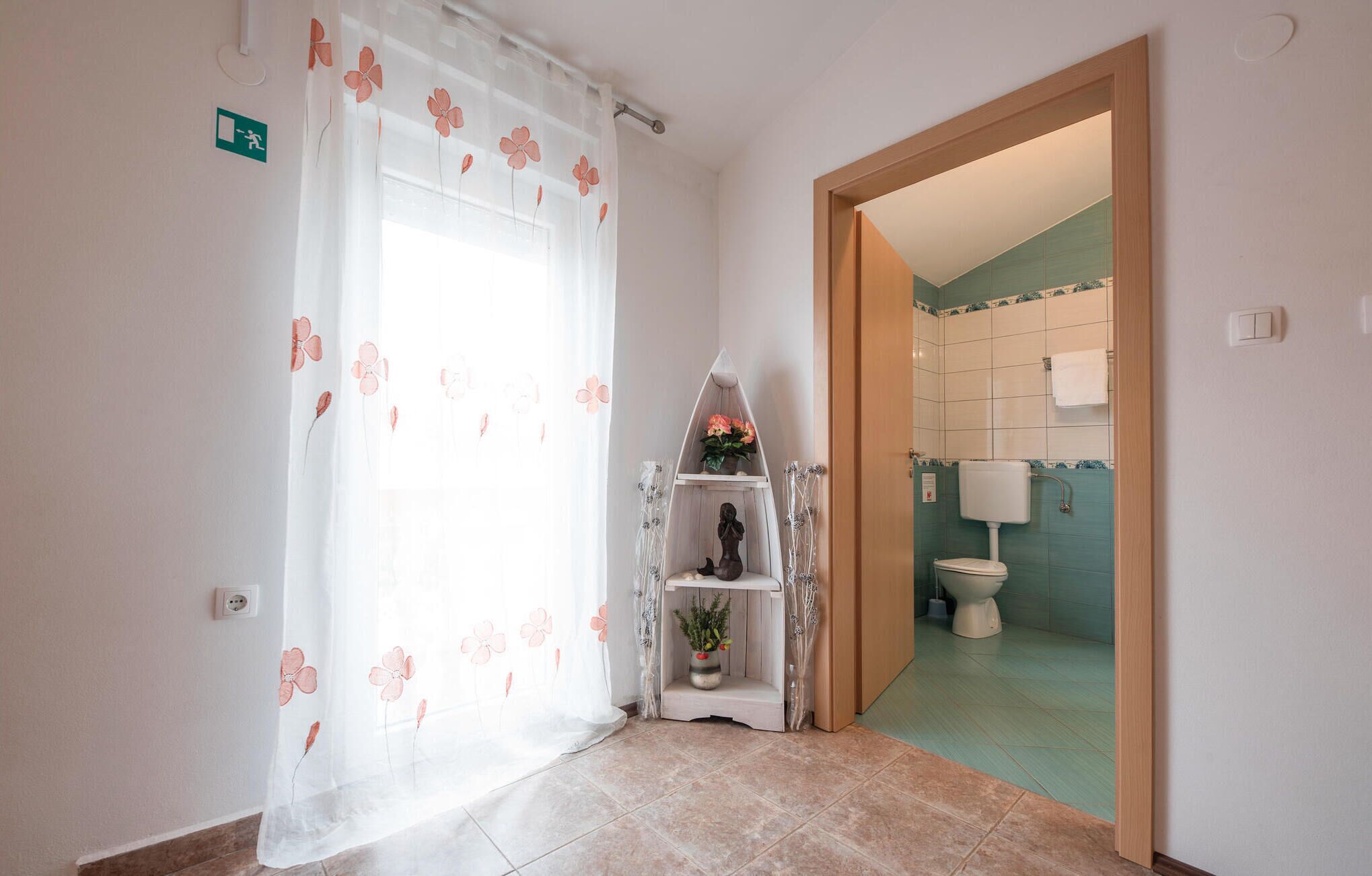 Et badeværelse med toilet, vask og bruseområde.