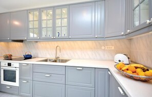 Enjoy a clean and organized kitchen with sleek cabinetry, stainless steel sink, and oven.