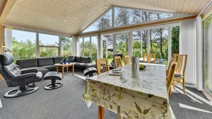 Amplia habitación con un gran comedor, asientos cómodos y ventanas amplias que ofrecen vistas al exterior.
