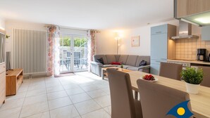 A modern kitchen with a dining area, a sofa, and a view of the outdoors. - Apartment (Appartment) Curr 02 Garden Street -. Apartment (Appartment) Curr 02 Garden Street. (Heringsdorf)
