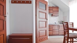 A modern kitchen with wooden cabinets, a dining table with chairs, and a bench. - Amazing apartment in Goscino with WiFi (Goscino)