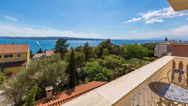 A balcony with a view of the sea, a tiled roof, and a table with chairs. - Studio with air conditioning (Crikvenica)