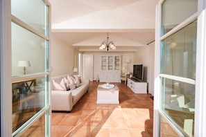 A spacious living room with a sofa, coffee table, and television.