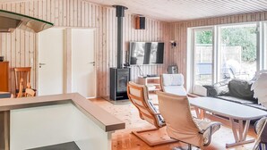 Eine moderne Küche mit Holzwänden, einem eingebauten Herd und einem großen Fenster.