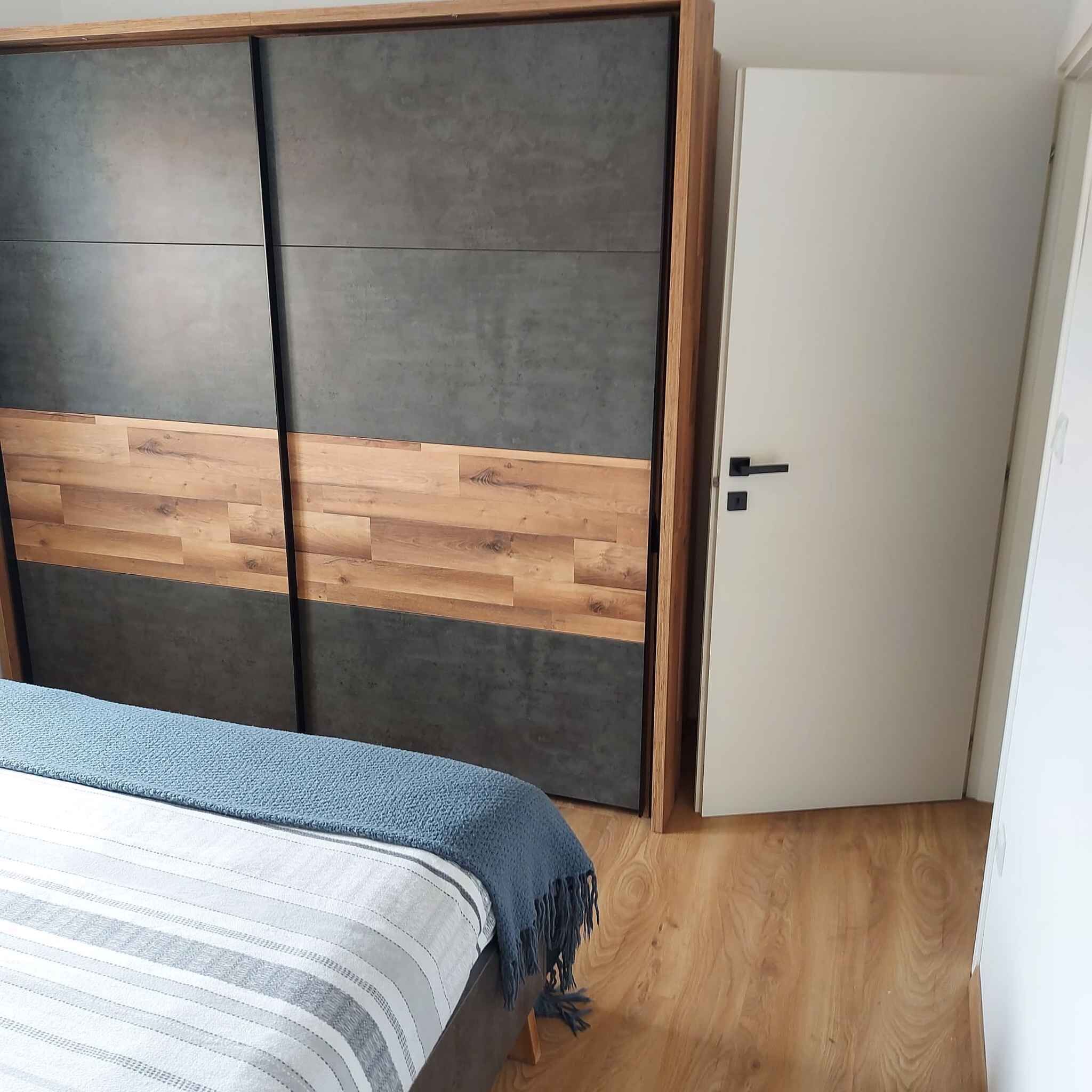 Une chambre à coucher avec un lit, une armoire et une porte.