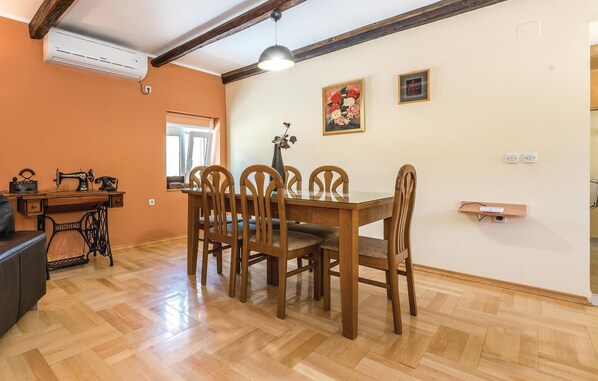 A dining area with a wooden table and chairs, a vintage Singer sewing machine, and a window with a view.