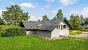 Ein kleines, eingeschossiges Gebäude mit Satteldach, einer Tür und einem Fenster.