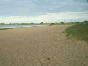 A sandy beach with a body of water in the background.