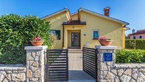 A yellow building with a stone entrance gate, a small tower, and potted plants. - Amazing home in Labin (Labin)