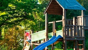 A wooden playground structure with a slide and climbing area. - Apartment 2 - The Mouse - Vacation at Duckwitz Castle (Behren-Lübchin)