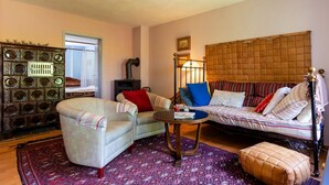 Un salon chaleureux avec un ensemble de canapés, un tapis à motifs et un meuble décoratif.