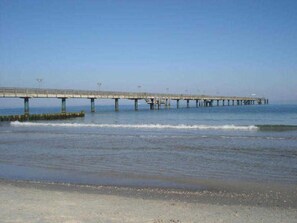Un muelle largo que se adentra en el agua, bajo un cielo despejado.