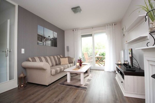 Un salon moderne avec un canapé, une table basse et une cheminée.