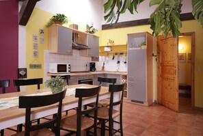 Cozinha compacta com área de refeições, com micro-ondas, fogão e armários.