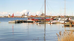 Ein Hafen mit vertäuten Booten, einer Flagge und einem Gebäude im Hintergrund.