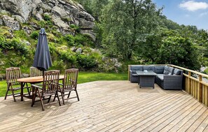 A wooden deck with a table and chairs, a sofa, and an umbrella. - Stunning home in Farsund with ethernet internet (Farsund)