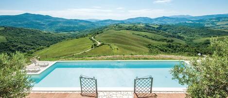 A pool with a view of rolling hills and mountains.