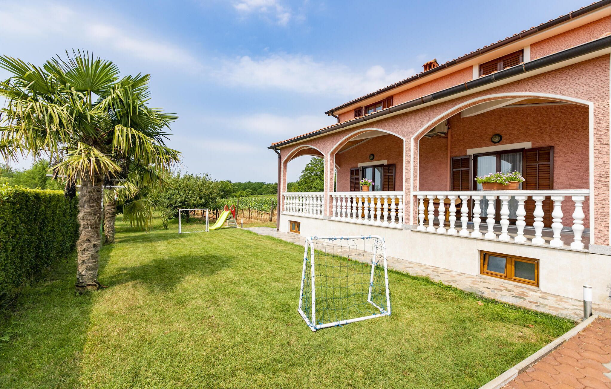A house with a covered porch, a lawn, and a soccer goal.