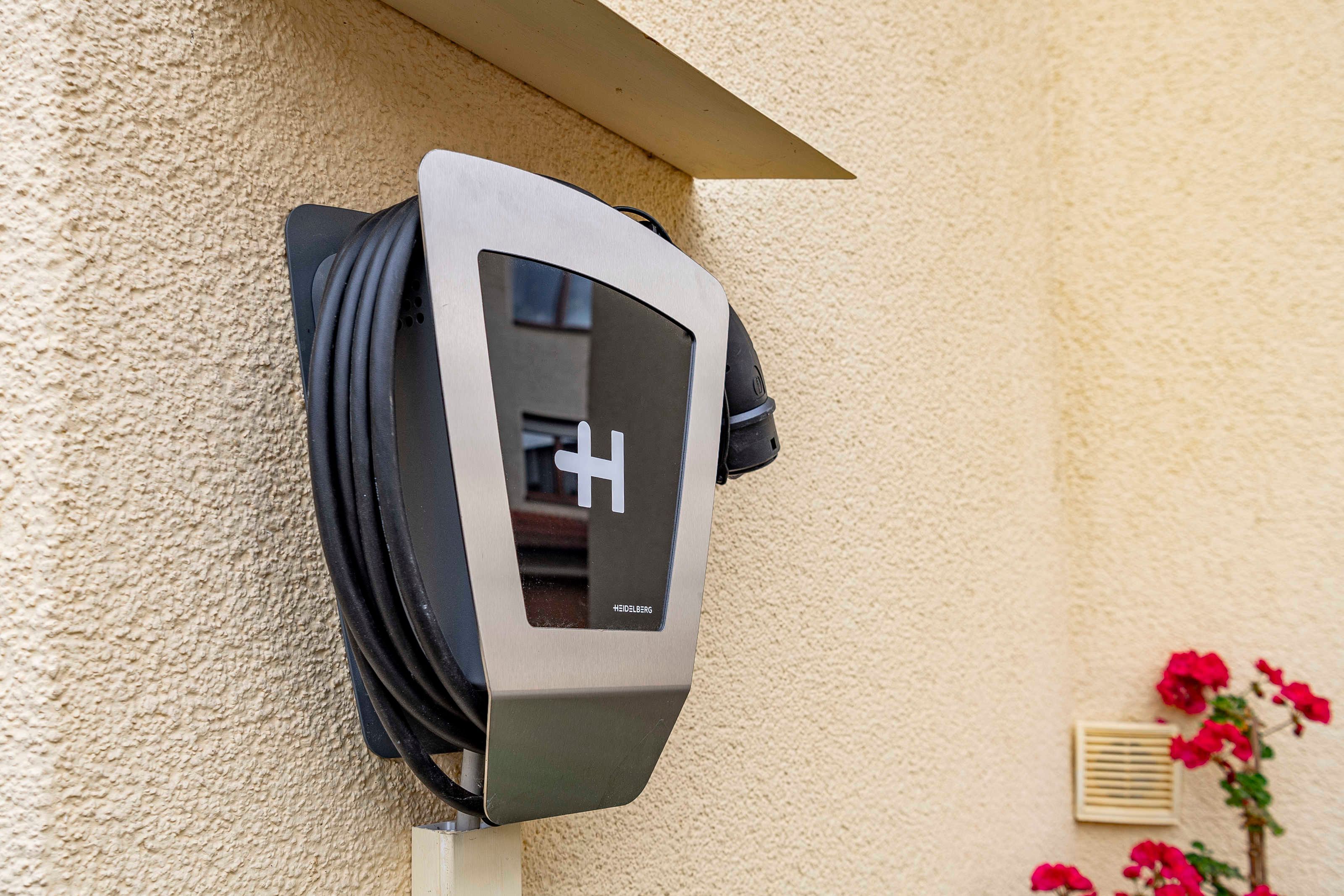 An electric vehicle charging station mounted on a textured wall.