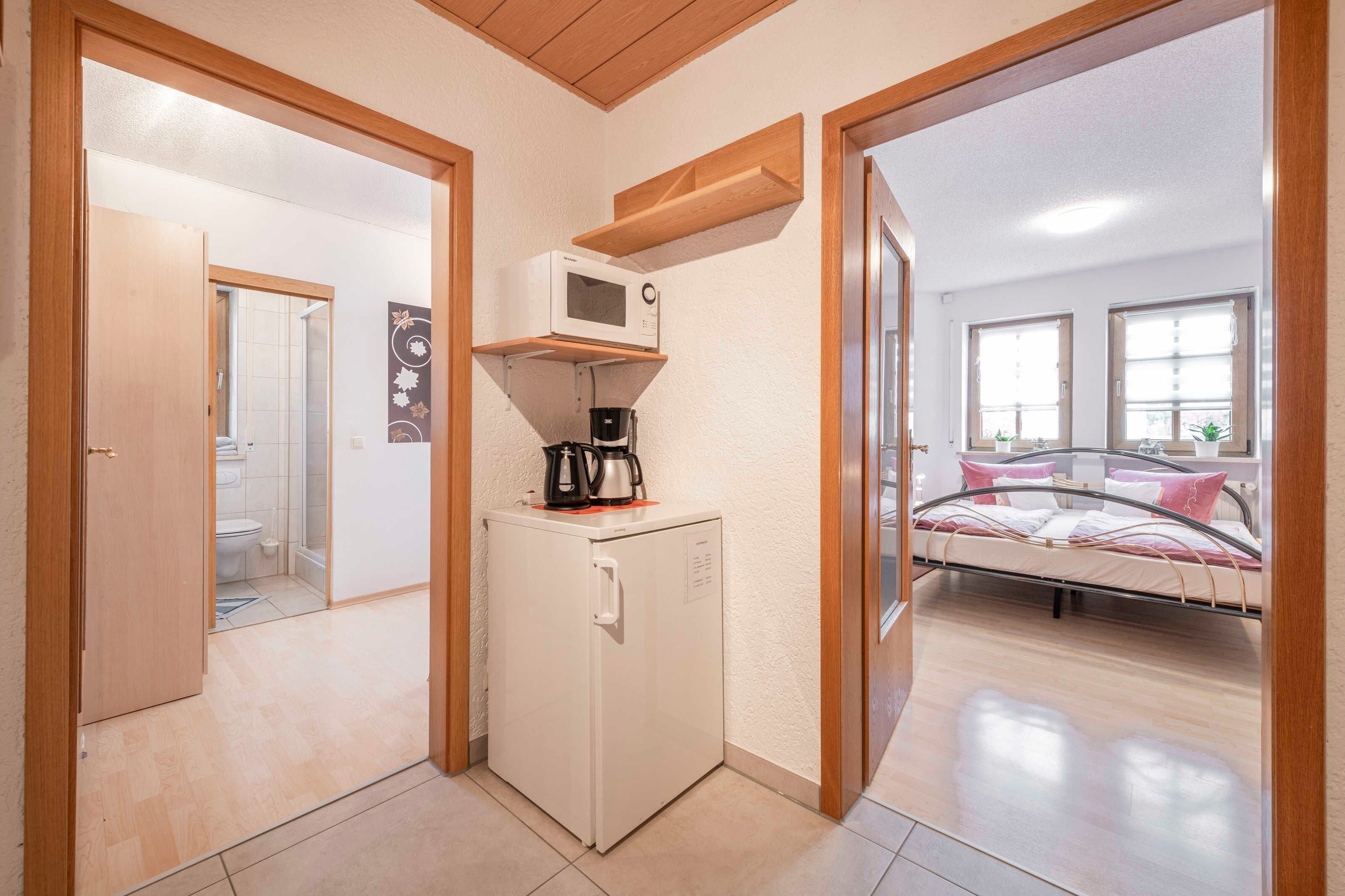 Ein kleines Zimmer mit Küchenzeile, einem Bett und einem Badezimmer.
