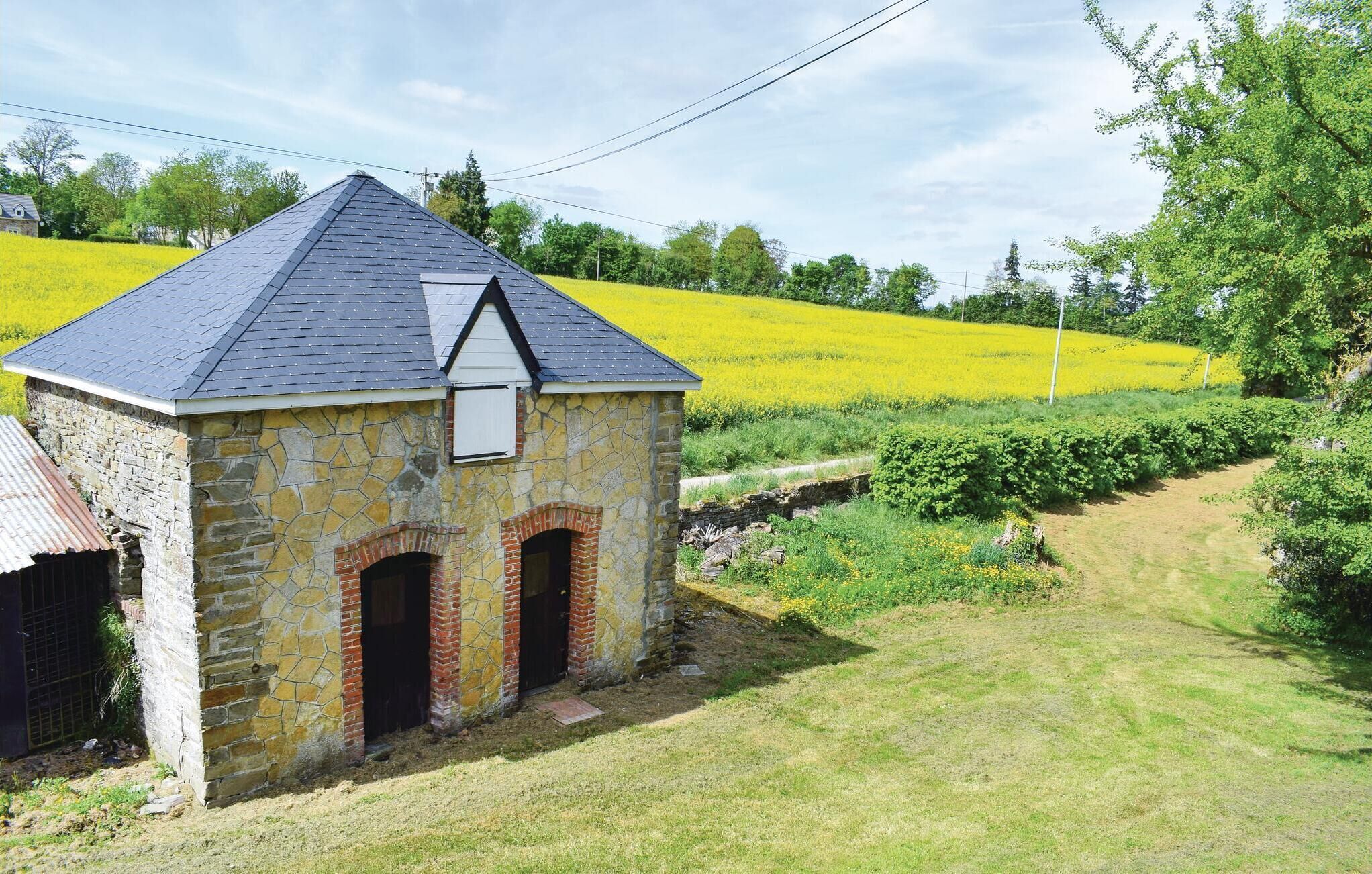 A stone building with a sloped roof, two arched doorways, and a small window.