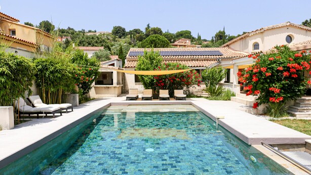 A rectangular swimming pool with a tiled floor, surrounded by lounge chairs and red flowering bushes. - Amazing home in Rochefort (Rochefort)