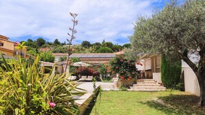 A courtyard with a seating area, steps leading to a building, and a variety of plants. - Amazing home in Rochefort (Rochefort)