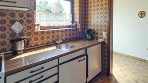 Een keuken met een spoelbak, een koffiezetapparaat en een waterkoker.