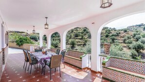 A covered outdoor dining area with a table set for four, surrounded by wicker chairs. - Amazing home in Torrox Costa with WiFi (Torrox Costa)
