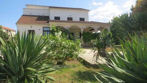 A two-story building with a tiled roof and a courtyard with arches.
