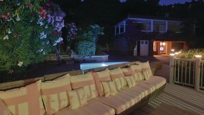 Un espace aménagé au bord de la piscine, avec un canapé en osier et une petite piscine.