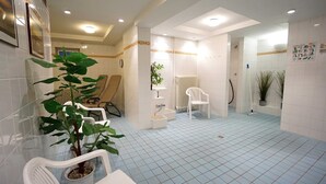 A clean, well-lit bathroom with white tiles, a plant, a white chair, and a radiator. - Beach Park Heringsdorf - near the beach / first row - apartment 3. 24 (Heringsdorf)