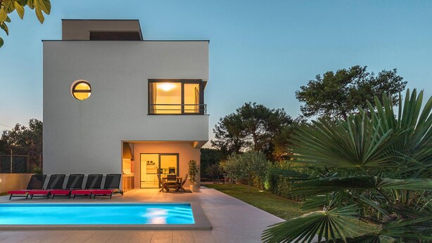 A modern two-story house with a swimming pool, outdoor seating, and a well-maintained garden. - Beach front home in Premantura (Premantura)
