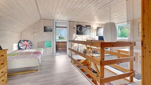 Una habitación acogedora de madera con una cama, un escritorio y una litera.