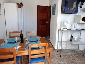 Enjoy a casual dining experience in this cozy space with a table set for two, featuring a bottle of wine and clear glassware.