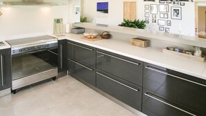 A modern kitchen with black cabinets, stainless steel appliances, and a white countertop. - Gorgeous home in St.Aubin de Cadelech (St.Aubin de Cadeleche)