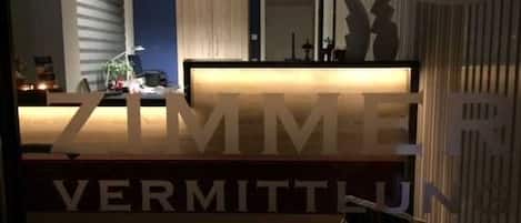 A reception desk with a sign that reads 'ZIMMER VERMITTUN'.