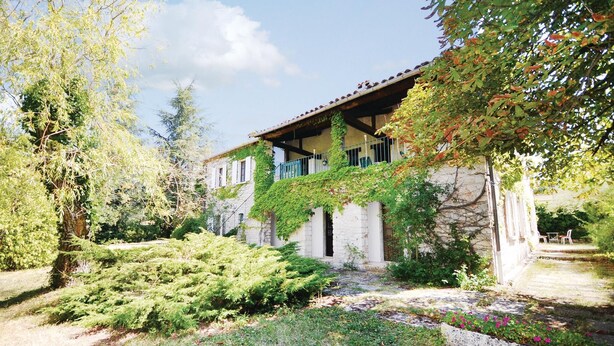 A house with a stone facade, ivy-covered walls, and a garden with various shrubs and flowers. - 3 bedroom cozy home in Sault (Sault)