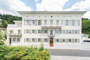A multi-story building with a balcony, a door, and a window with shutters. - Apartment - PALACE AM SEE (Tegernsee)
