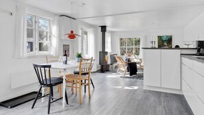 Une cuisine moderne dotée d’un îlot central, de meubles blancs et d’une grande fenêtre.