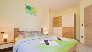 Un dormitorio moderno con cama, mesitas de noche y una obra de arte en la pared.
