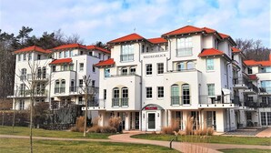 A multi-story building with a red roof, balconies, and a sign that reads 'MEERESBLICK.'