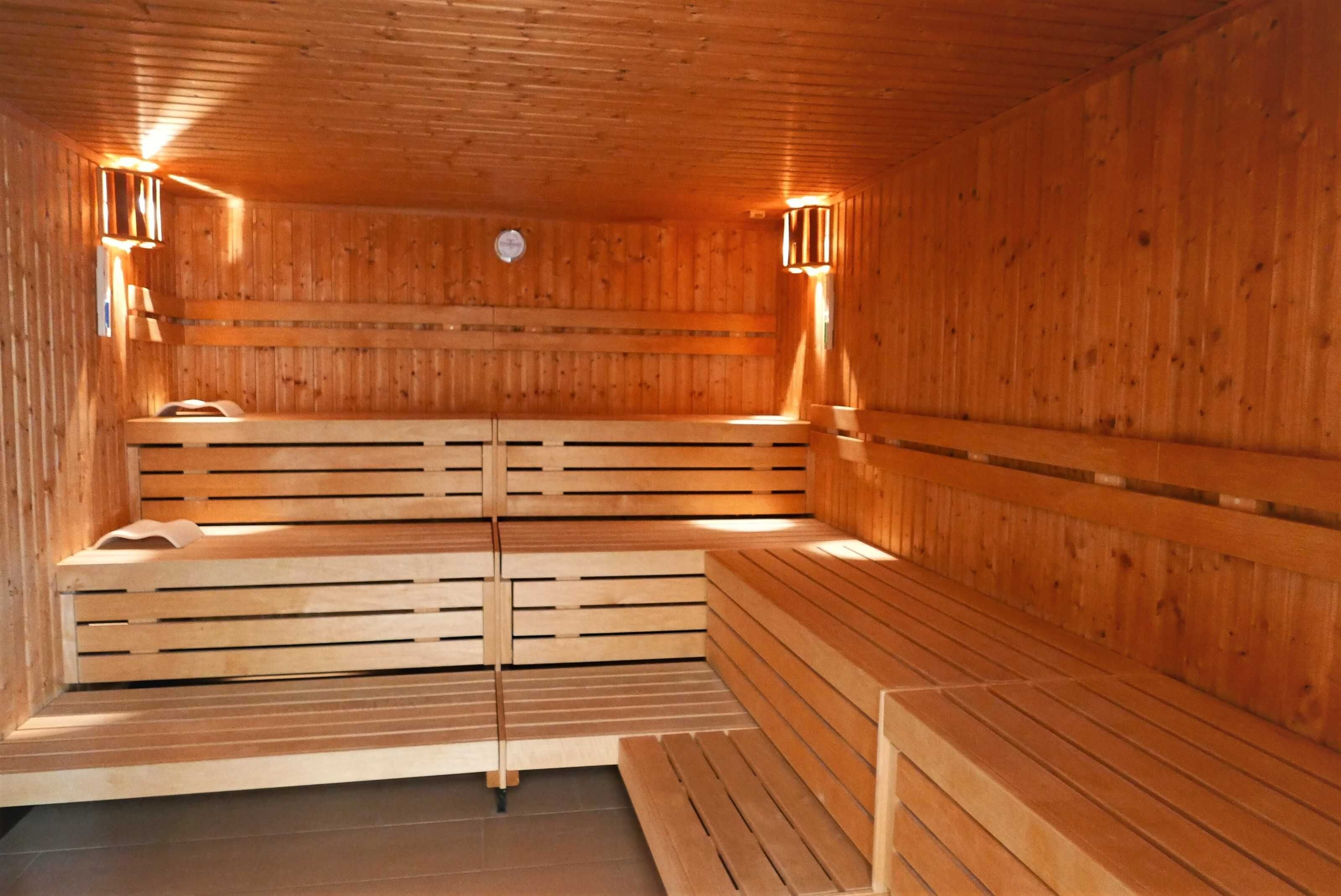 Una sauna de madera con bancos y luces en la pared.