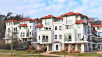 A multi-story building with a red roof, balconies, and a sign that reads 'MEERESBLICK.'