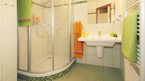 Une salle de bain avec une douche à parois de verre, un lavabo et un miroir.