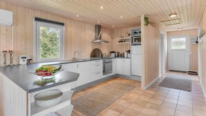 Una cucina moderna con pannelli in legno, un'ampia finestra e un forno integrato.