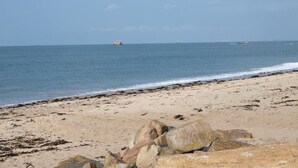 A beach with a rocky foreground and calm sea. - 1 bedroom beautiful home in Pleubian (Pleubian)