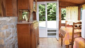 A wooden interior with a stone wall, a wooden cabinet, a table with a tablecloth, and a chair. - 1 bedroom beautiful home in Pleubian (Pleubian)