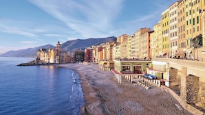 A coastal town with colorful buildings, a prominent church with a bell tower, and a beach with a wooden walkway. - Nice apartment in Rapallo GE with swimming pool (Rapallo GE)